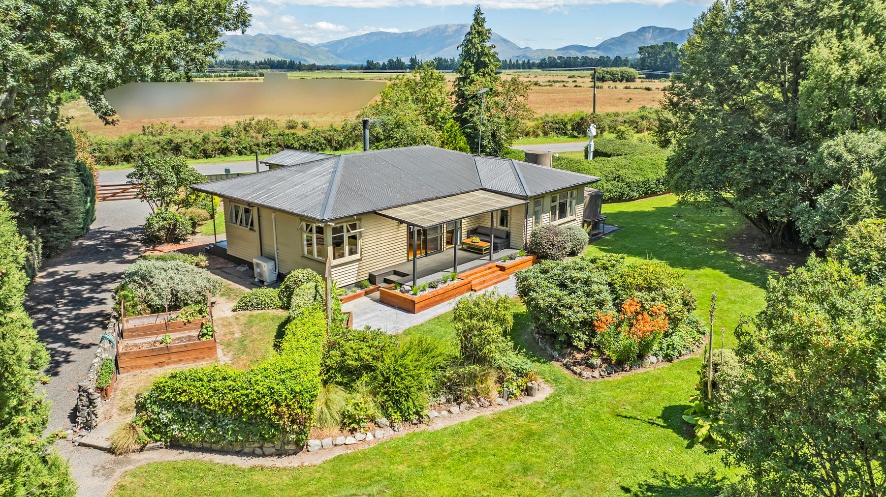 Aerial view of Kowai Farmstay house and gardens with Southern Alps in background