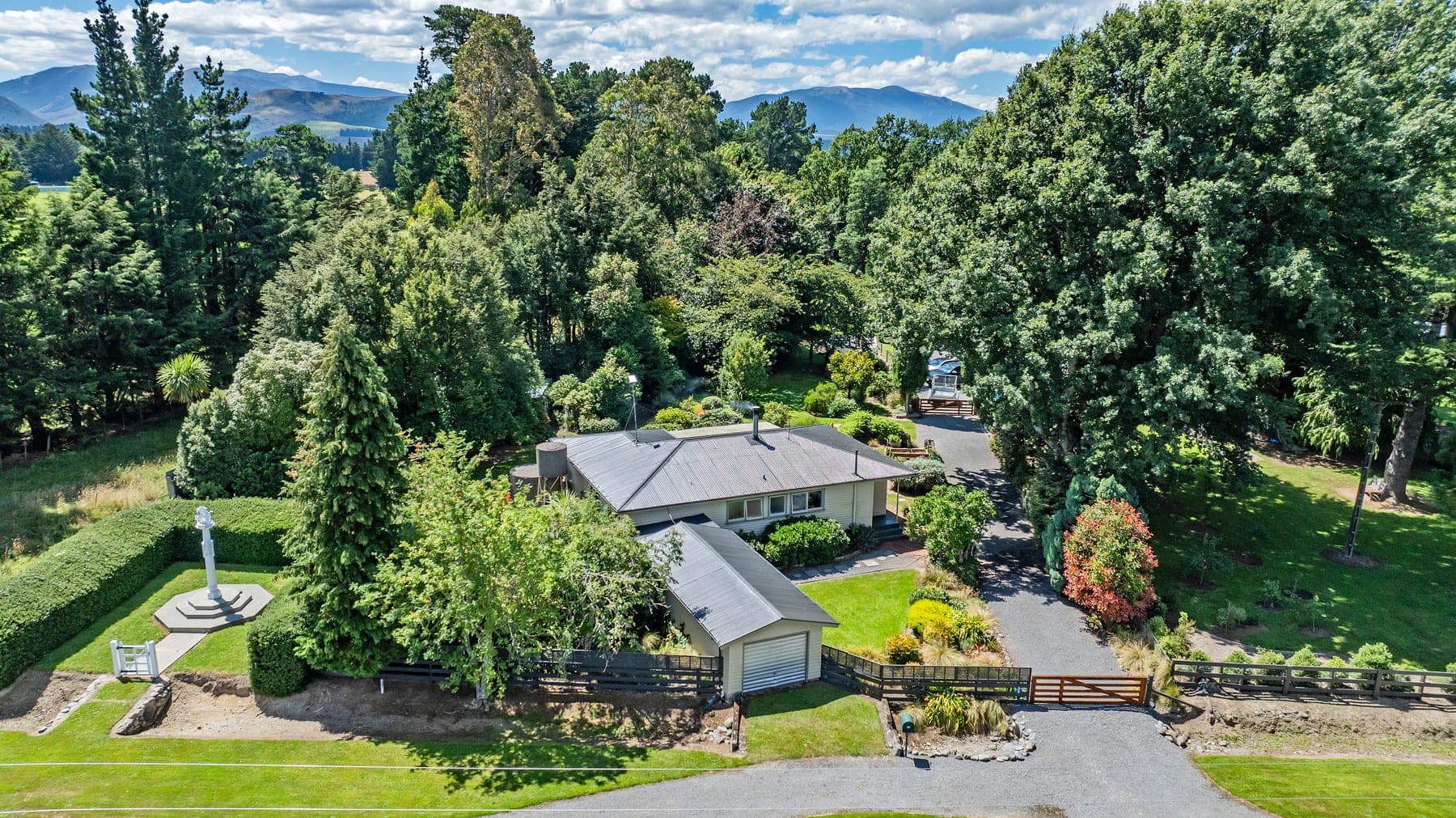 Aerial view of Kowai Farmstay nestled in trees with Canterbury mountains behind